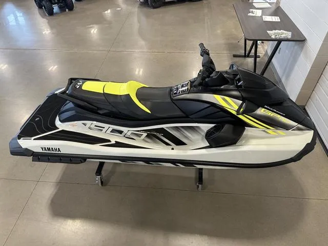 Slide: The Image of 2025 Yamaha Waverunner GP jet ski with sleek black and yellow design on display indoors. - 8