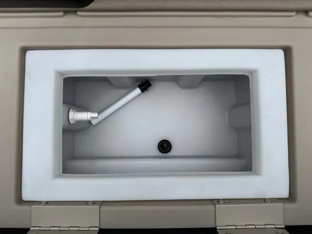 Slide: The Image of 2024 Bennington 22 SSR Tri-Toon Pontoon storage compartment with white interior and drainage. - 12