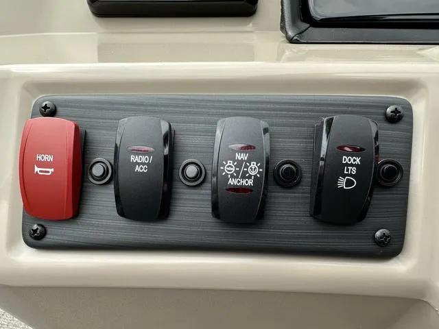 Slide: The Image of Control panel of 2024 Bennington 22 SSR Tri-Toon Pontoon with switches for horn, radio, navigation, and dock lights. - 40