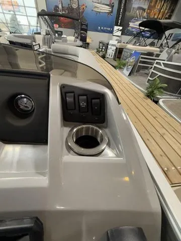 Slide: The Image of 2024 Bennington 208SLJ boat dashboard with switches and cup holder. - 14