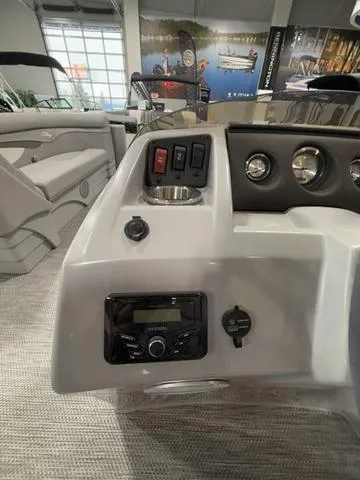 Slide: The Image of 2024 Bennington 208SLJ boat dashboard with controls and stereo system in showroom. - 15