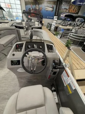 Slide: The Image of 2024 Bennington 208SLJ boat interior with steering wheel and control panel in showroom. - 16
