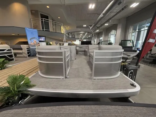 Slide: The Image of 2024 Bennington 208SLJ pontoon boat displayed in a showroom setting. - 2