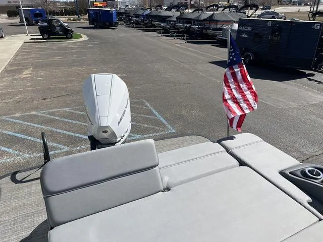 Slide: The Image of 2024 Bennington 25RX Swingback ESP Tri-Toon Pontoon with American flag and outboard motor. - 23