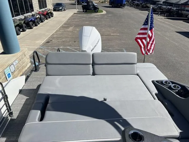 Slide: The Image of 2024 Bennington 25RX Swingback ESP Tri-Toon Pontoon with American flag, docked at marina. - 24