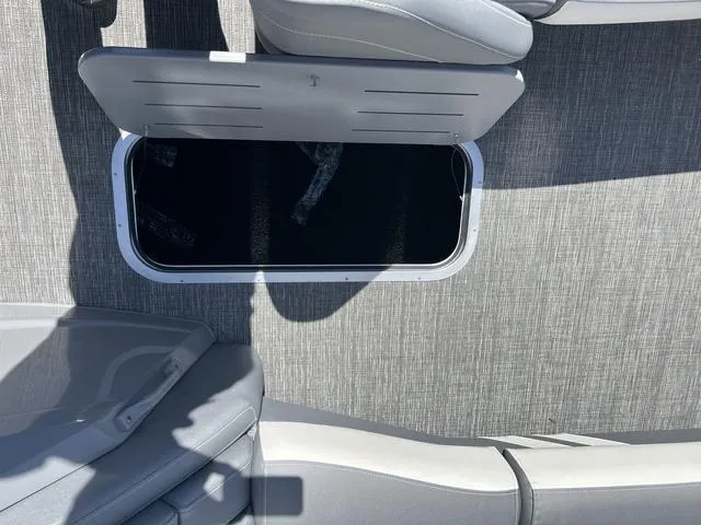 Slide: The Image of 2024 Bennington 25RX Swingback ESP Tri-Toon Pontoon with open storage compartment on deck. - 27