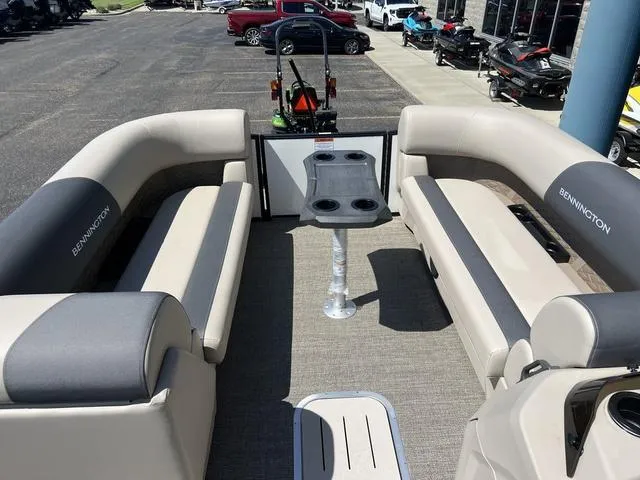 Slide: The Image of 2024 Bennington 22SSB-SPS pontoon boat interior with beige seating and central table. - 11