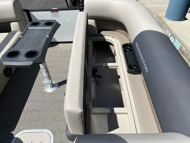 Slide: The Image of 2024 Bennington 22SSB-SPS boat interior with seating, storage, and table with cup holders. - 12