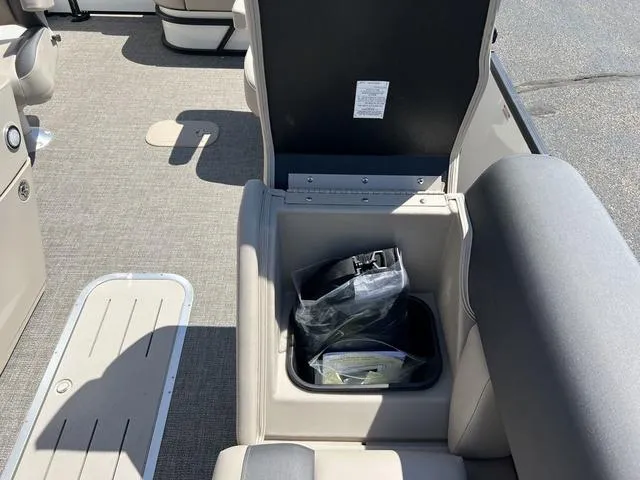 Slide: The Image of 2024 Bennington 22SSB-SPS boat interior storage compartment with open lid and items inside. - 16