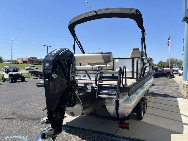 Slide: The Image of 2024 Bennington 22SSB-SPS pontoon boat with outboard motor, parked outdoors. - 5