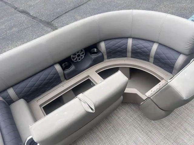 Slide: The Image of 2019 Bennington 23 SSBXP boat interior with gray seating, storage compartments, and speaker system. - 14