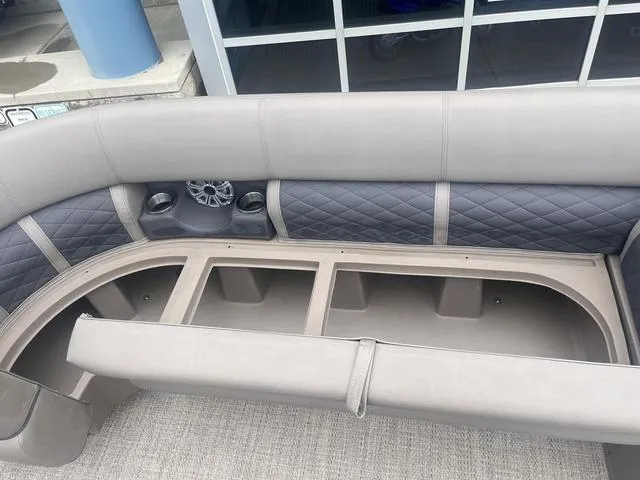 Slide: The Image of 2019 Bennington 23 SSBXP boat interior with gray seating, cup holders, and storage compartments. - 15