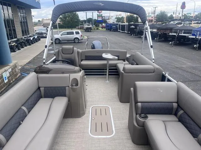 Slide: The Image of 2019 Bennington 23 SSBXP pontoon boat with spacious seating and canopy in a dealership lot. - 6