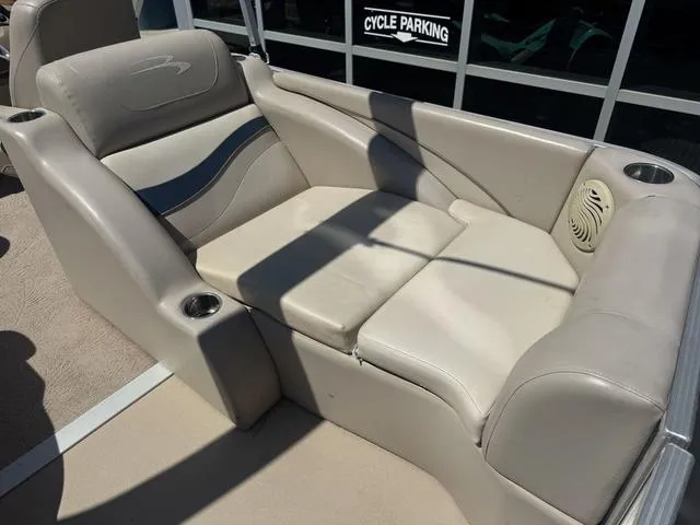 Slide: The Image of 2010 Bennington 2250RCW Pontoon seating area with beige upholstery and cup holders. - 17