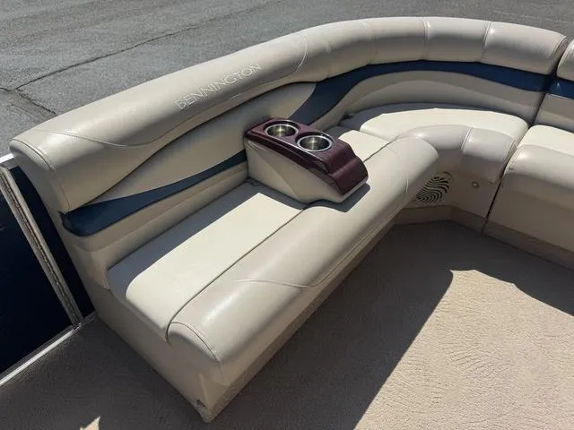 Slide: The Image of 2010 Bennington 2250RCW Pontoon seating with cup holders, featuring beige and blue upholstery. - 35