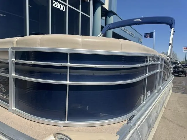 Slide: The Image of 2010 Bennington 2250RCW Pontoon boat with blue panels and beige seating, docked outdoors. - 5