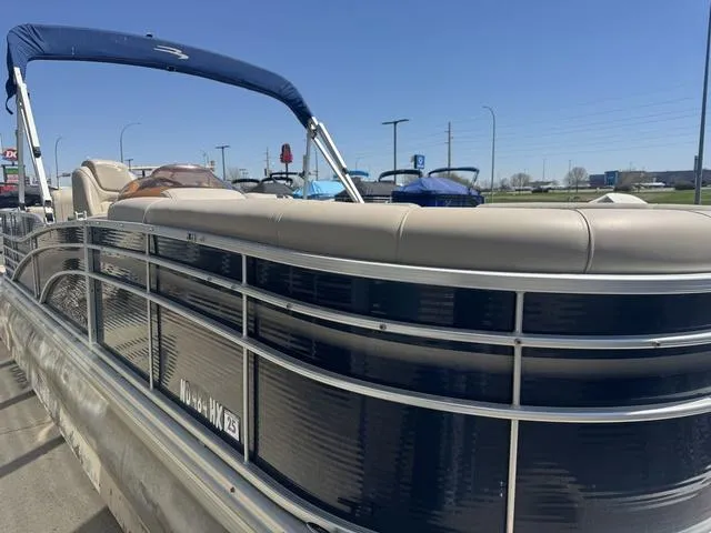 Slide: The Image of 2010 Bennington 2250RCW Pontoon boat with blue canopy, parked outdoors under clear sky. - 8