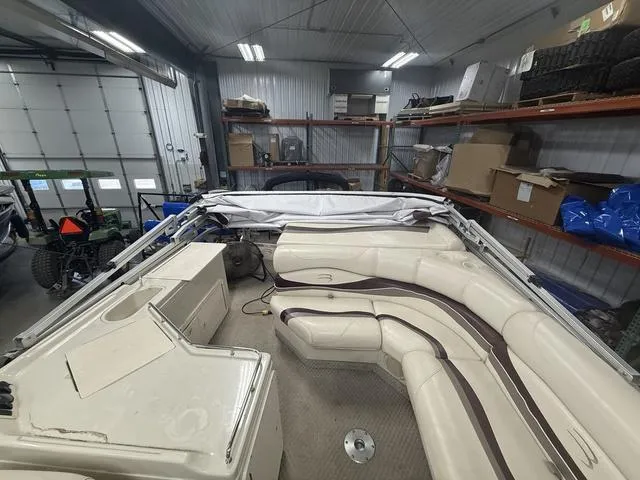 Slide: The Image of 2005 Bennington 2575RLX Pontoon boat interior in storage, featuring beige seating and equipment. - 3