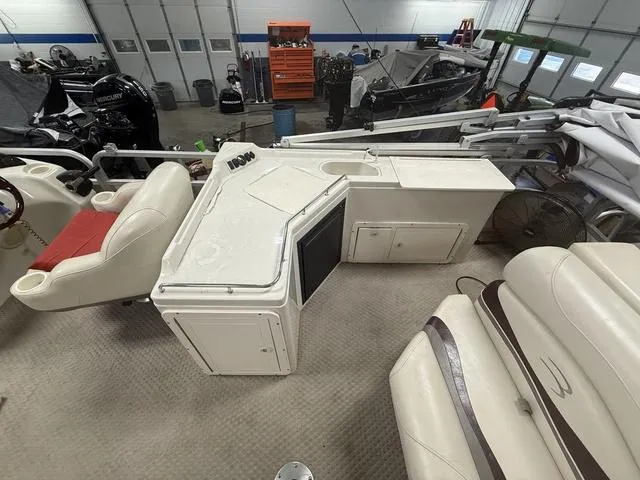 Slide: The Image of 2005 Bennington 2575RLX Pontoon interior with seating and control console in a garage setting. - 4