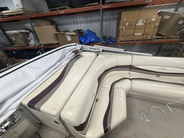 Slide: The Image of 2005 Bennington 2575RLX Pontoon boat interior with cream and brown seating in storage. - 5