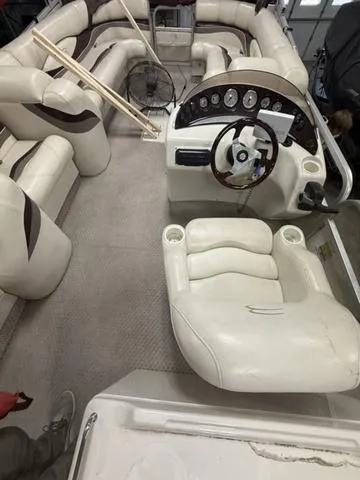 Slide: The Image of 2005 Bennington 2575RLX Pontoon interior with plush seating and steering console. - 7
