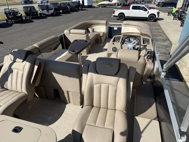 Slide: The Image of 2019 Bennington 21 SSX pontoon boat with beige interior, spacious seating, and modern dashboard. - 10