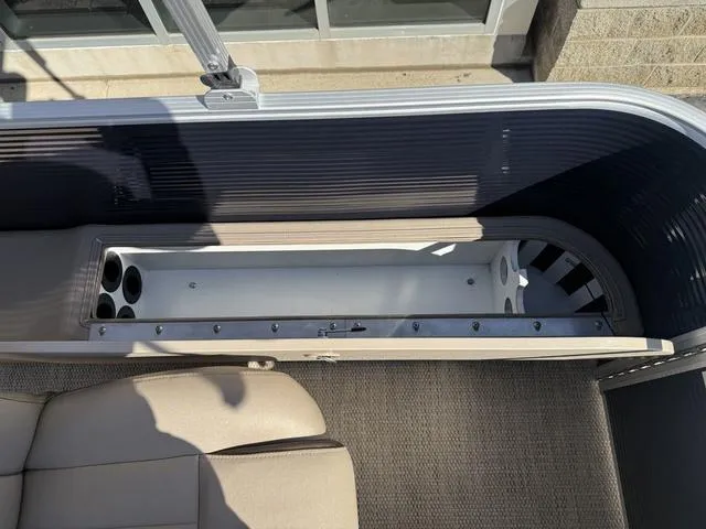 Slide: The Image of 2019 Bennington 21 SSX boat interior with open storage compartment and cup holders. - 16