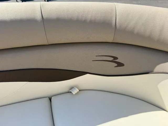 Slide: The Image of 2019 Bennington 21 SSX boat interior with beige cushioned seating. - 32