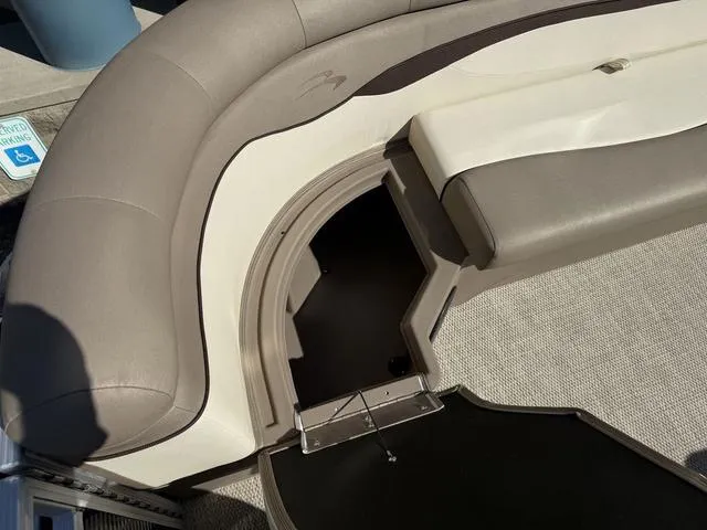 Slide: The Image of 2019 Bennington 21 SSX boat interior with beige seating and storage compartment. - 35