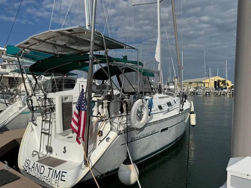 Slide: The Image of Sailboat Beneteau 343, 2008 model, docked at marina with American flag. - 1