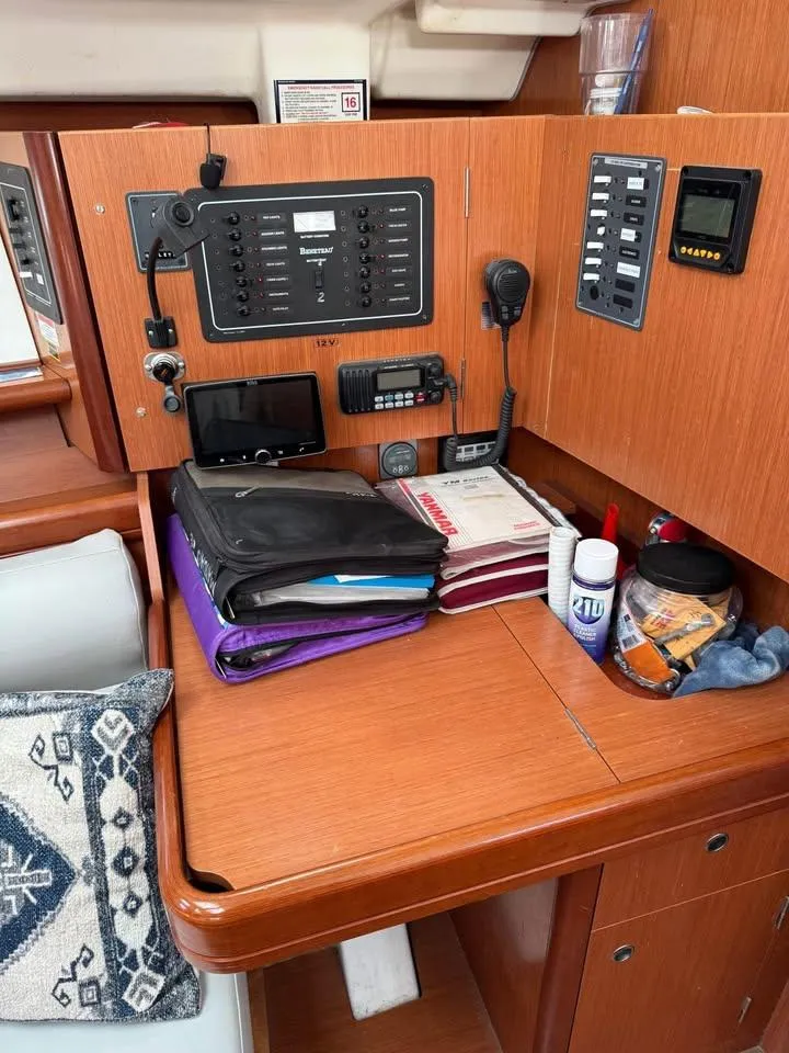 Slide: The Image of Navigation station of a 2008 Beneteau 343 sailboat with control panels and organized documents. - 10