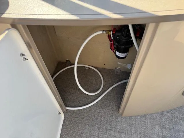 Slide: The Image of 2016 Regency 254 DL3 boat compartment with hose and pump system. - 11