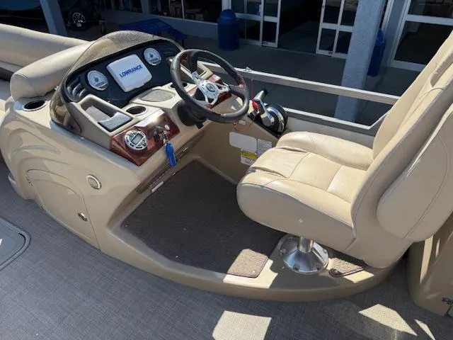 Slide: The Image of 2016 Regency 254 DL3 boat helm with beige seating and modern dashboard controls. - 14