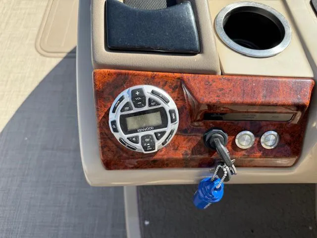 Slide: The Image of Control panel of a 2016 Regency 254 DL3 boat with Kenwood stereo and ignition keys. - 16