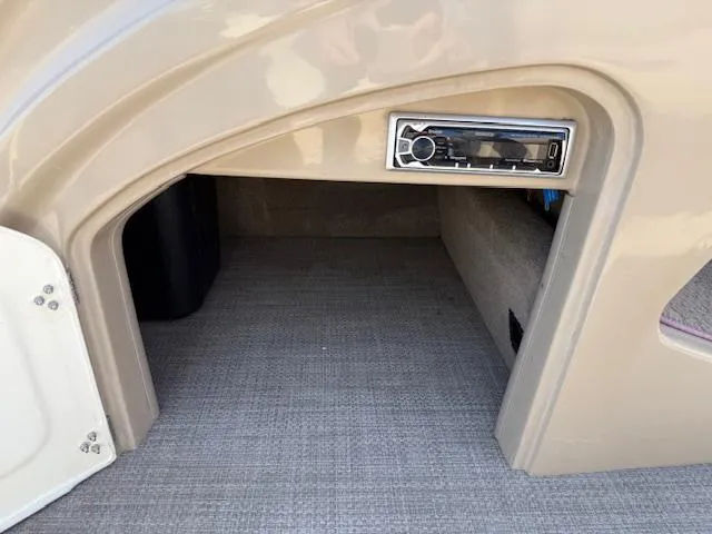 Slide: The Image of 2016 Regency 254 DL3 boat interior storage compartment with built-in stereo system. - 23