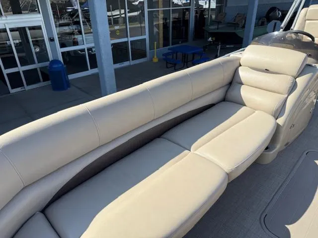 Slide: The Image of 2016 Regency 254 DL3 boat with beige seating, docked near a building. - 28