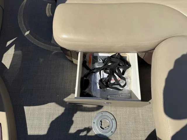 Slide: The Image of Open storage compartment in 2016 Regency 254 DL3 boat with beige seating and accessories. - 34