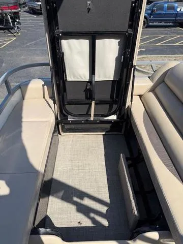 Slide: The Image of 2016 Regency 254 DL3 boat interior with beige seating and open storage compartment. - 37