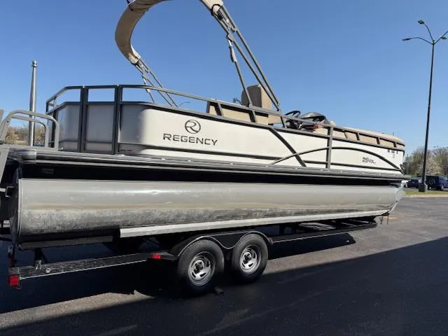 Slide: The Image of 2016 Regency 254 DL3 pontoon boat on a trailer, parked outdoors. - 38