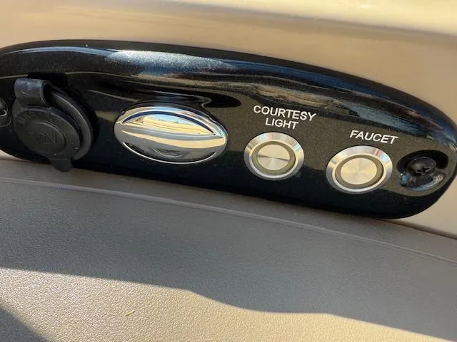Slide: The Image of Control panel of a 2016 Regency 254 DL3 boat with courtesy light and faucet buttons. - 9