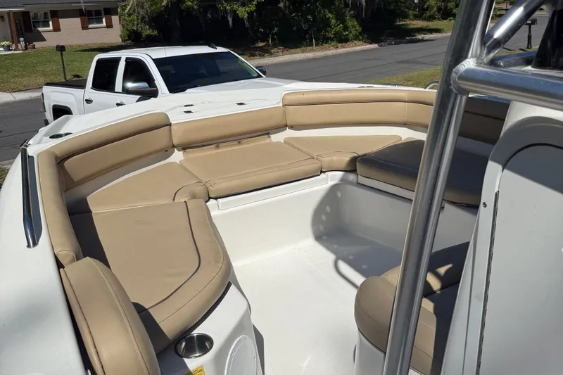 Slide: The Image of 2018 NauticStar 211 Hybrid boat with tan seating, parked near a white truck. - 7