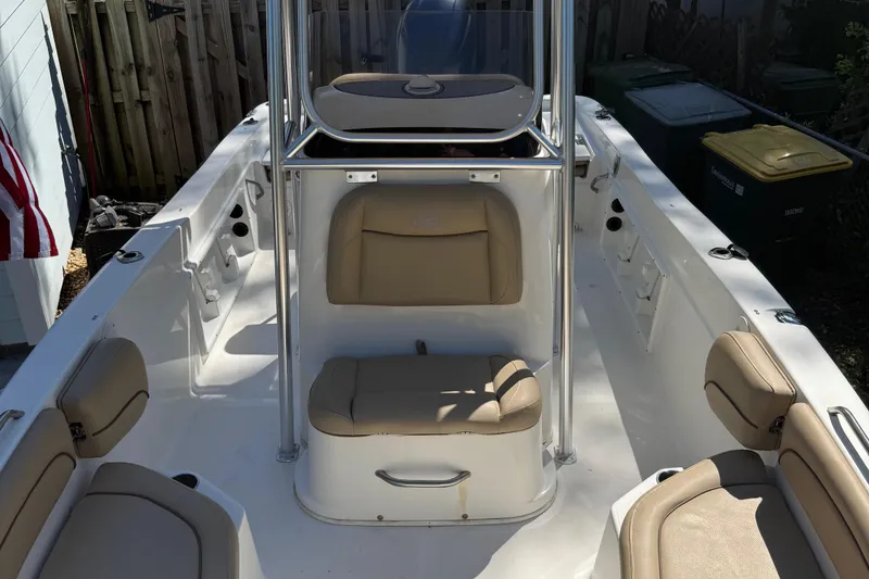 Slide: The Image of 2018 NauticStar 211 Hybrid boat interior with beige seating and center console. - 8