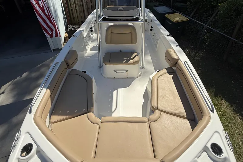 Slide: The Image of 2018 NauticStar 211 Hybrid boat interior with tan seating and center console. - 9