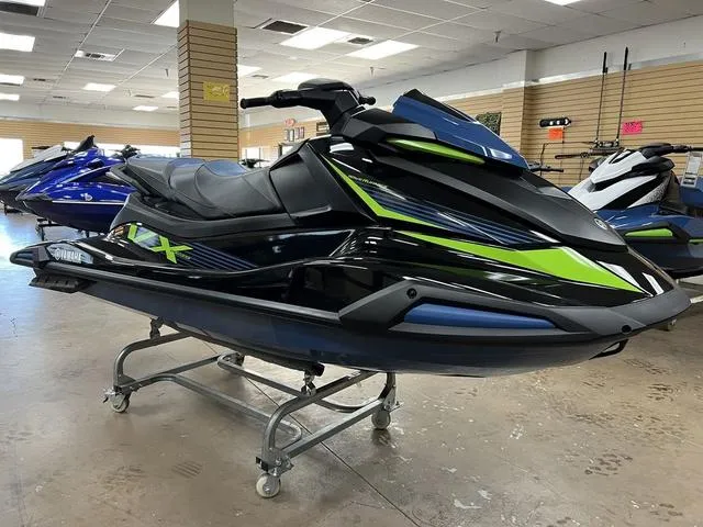 Slide: The Image of 2024 Yamaha Waverunner VX in showroom, sleek black and green design, on display stand. - 3