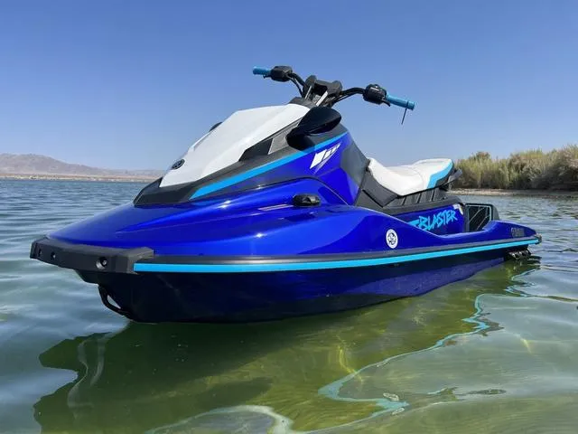 Slide: The Image of 2024 Yamaha Waverunner Jetblaster in vibrant blue on calm water. - 1