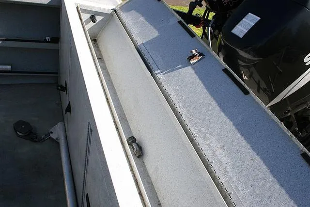 Slide: The Image of 2008 Fish Rite 20 Performer boat interior with storage compartment and motor. - 13