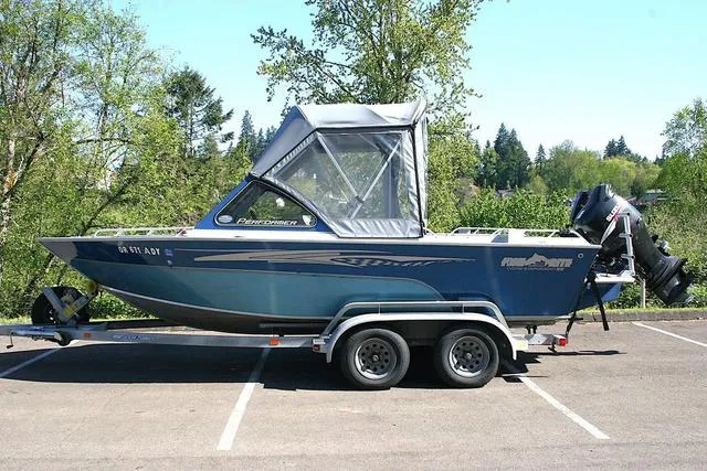 Slide: The Image of 2008 Fish Rite 20 Performer boat on trailer in parking lot, surrounded by trees. - 2