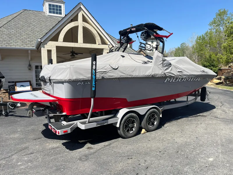 Slide: The Image of 2022 Moomba Makai boat on trailer, covered, parked near a house. - 10