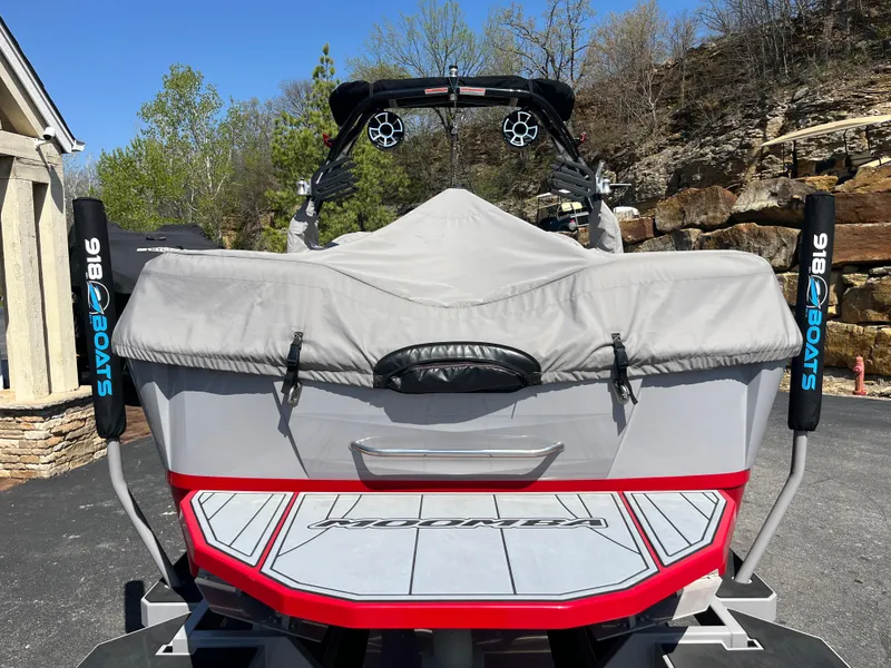 Slide: The Image of 2022 Moomba Makai boat with cover, parked outdoors, showcasing rear view and swim platform. - 12