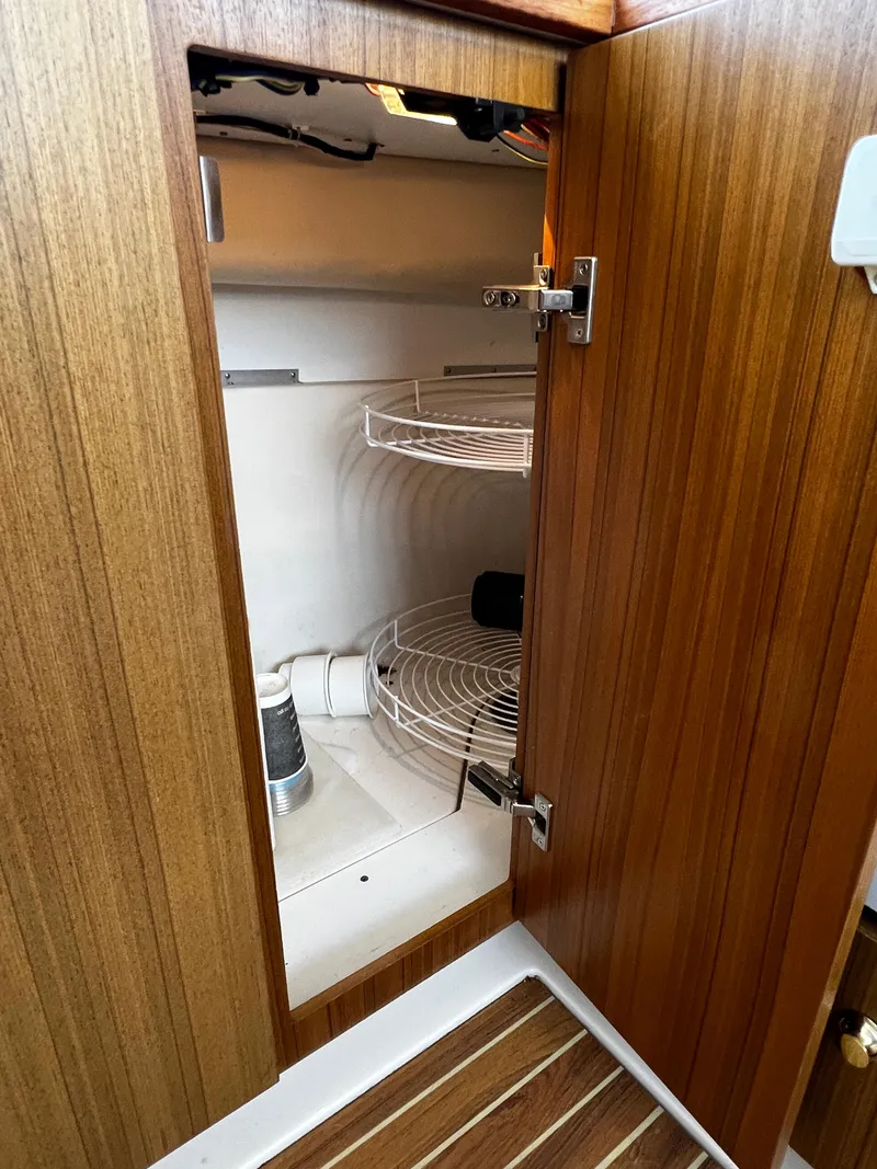 Slide: The Image of Open wooden cabinet with wire shelving in 2001 Bayliner 3488 Command Bridge Motoryacht. - 33